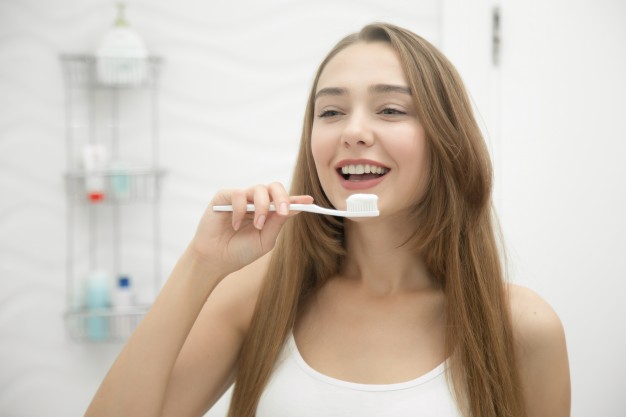 portrait-of-a-young-smiling-girl-cleaning-her-teeth_1163-2269